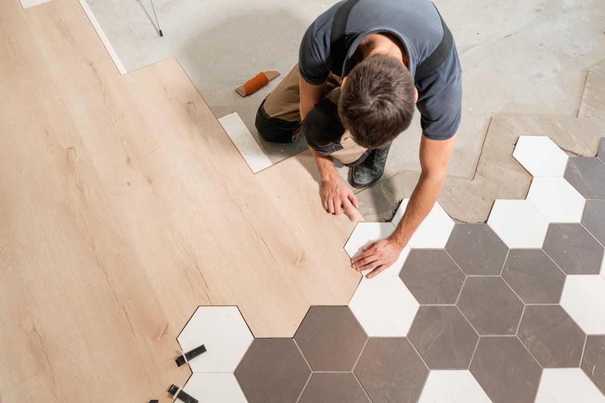 Professional flooring installer working on tile installation